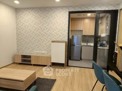 Modern living room with stylish kitchen and wooden flooring in a cozy apartment.