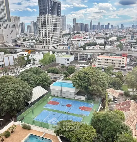 Stunning cityscape view with sports courts and lush greenery in a vibrant urban setting.