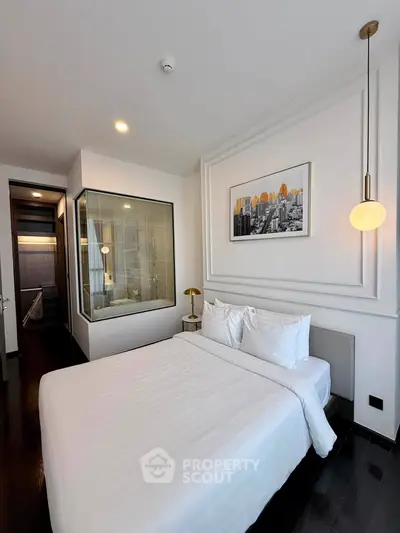 Modern bedroom with elegant decor and cityscape artwork, featuring a cozy bed and stylish lighting.