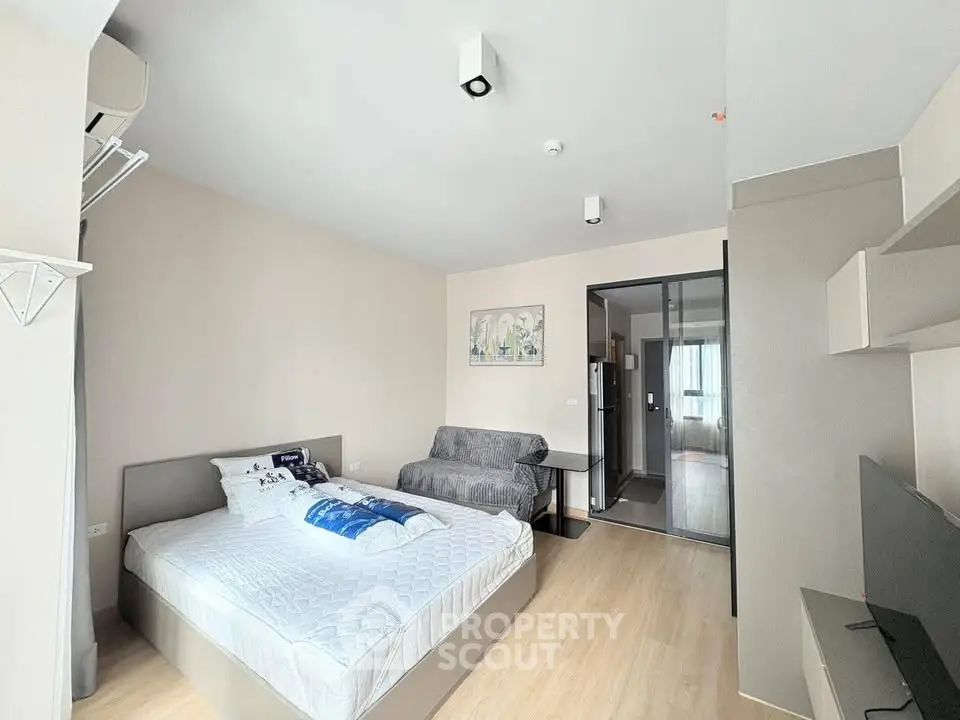 Spacious modern bedroom with cozy seating area and stylish decor