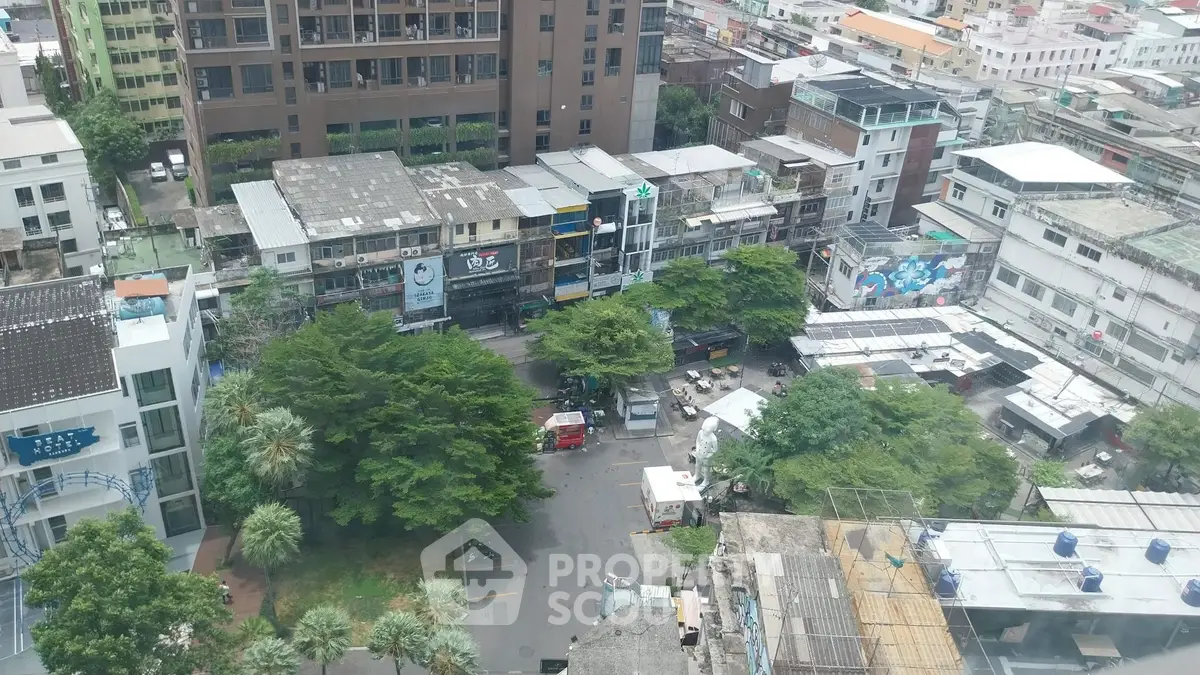 Aerial view of urban residential and commercial buildings with lush greenery.