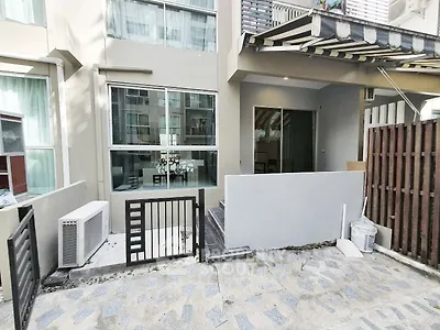 Modern townhouse exterior with large windows and small gated entrance