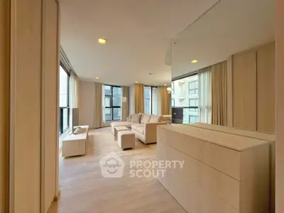 Spacious modern living room with large windows and elegant furniture in a luxury apartment.