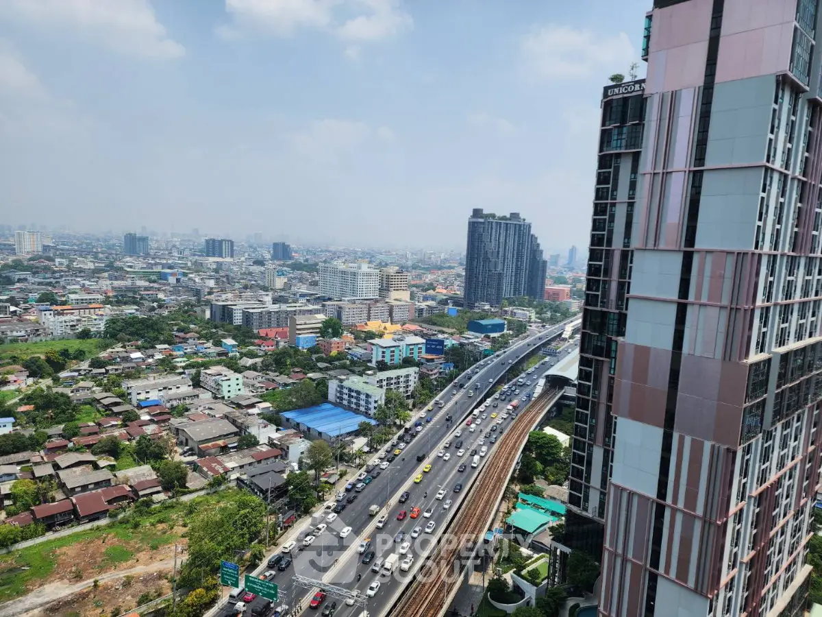 Stunning cityscape view from high-rise building showcasing urban skyline and bustling highway.
