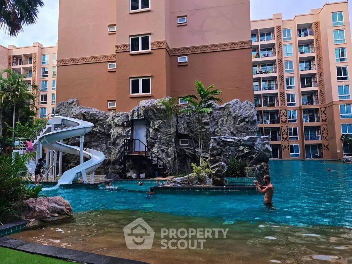 Luxurious apartment complex with stunning pool and waterslide, perfect for family living.