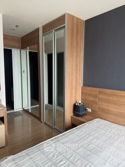 Modern bedroom with sleek wooden accents and mirrored closet doors