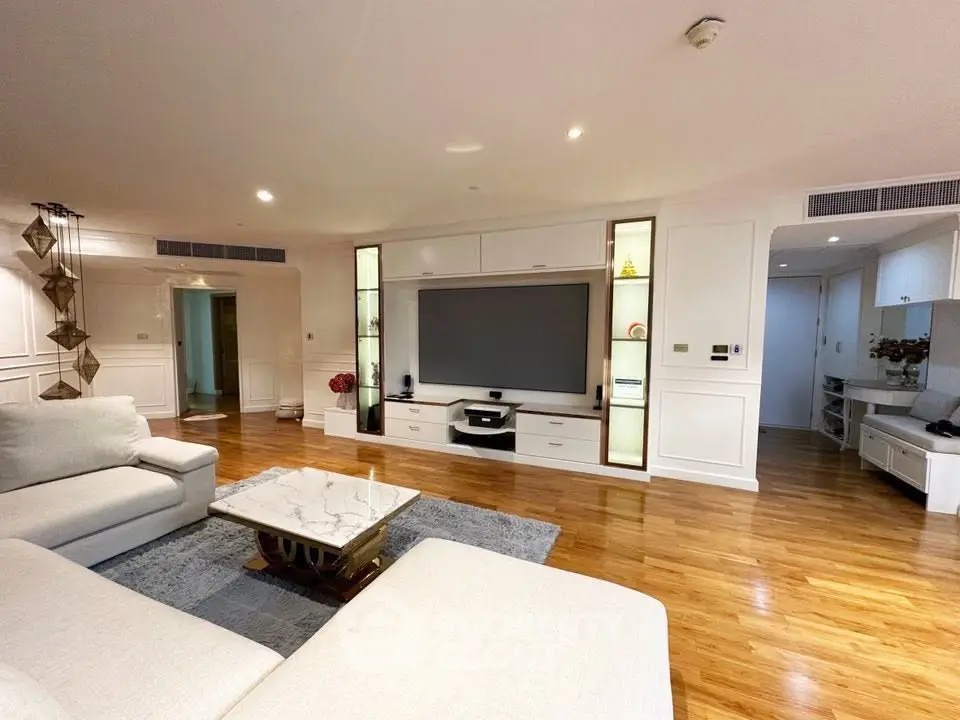 Spacious modern living room with hardwood floors and elegant built-in entertainment center.