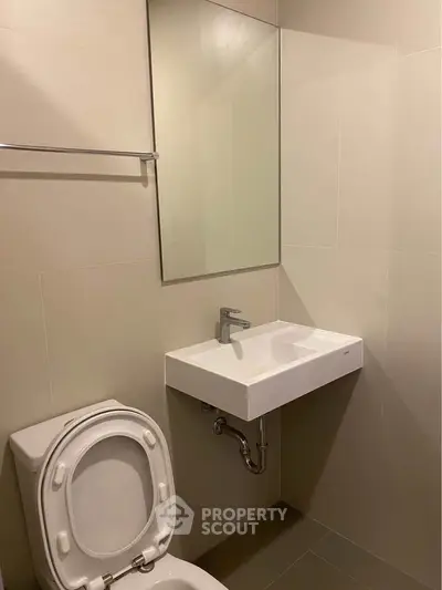 Modern bathroom with sleek sink and toilet in minimalist design.