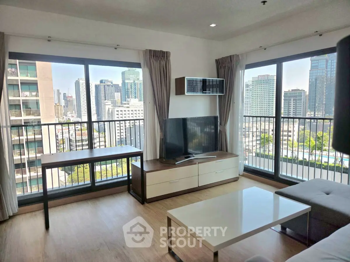 Spacious living room with city view and modern furnishings in high-rise apartment
