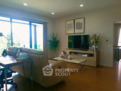 Spacious living room with modern decor and large windows offering natural light.