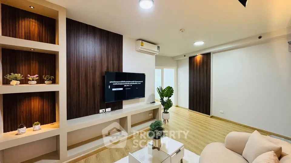 Modern living room with stylish decor and wooden accents, featuring a wall-mounted TV and cozy seating area.