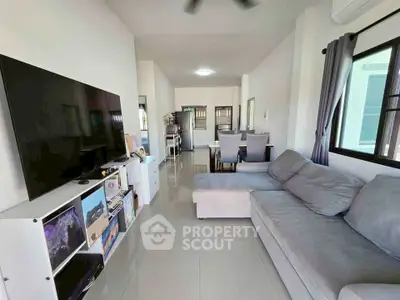 Spacious living room with modern decor and large TV, perfect for family gatherings.