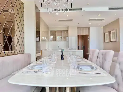Luxurious dining area with elegant table setting and modern kitchen in open layout apartment.