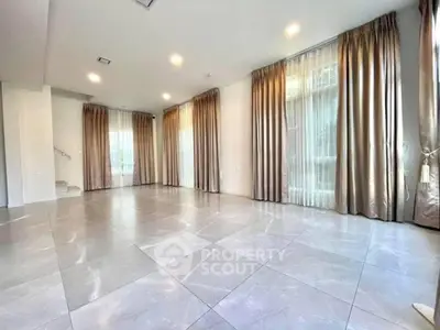 Spacious living room with elegant curtains and tiled flooring