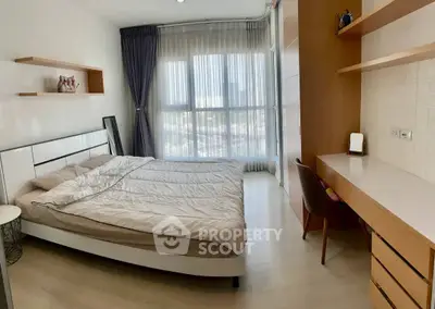 Modern bedroom with large window and stylish furniture in a bright apartment.