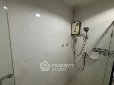 Compact bathroom with shower and white tiled walls, featuring a mounted water heater.