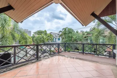Spacious balcony with stunning view of lush greenery and modern architecture, perfect for relaxation.