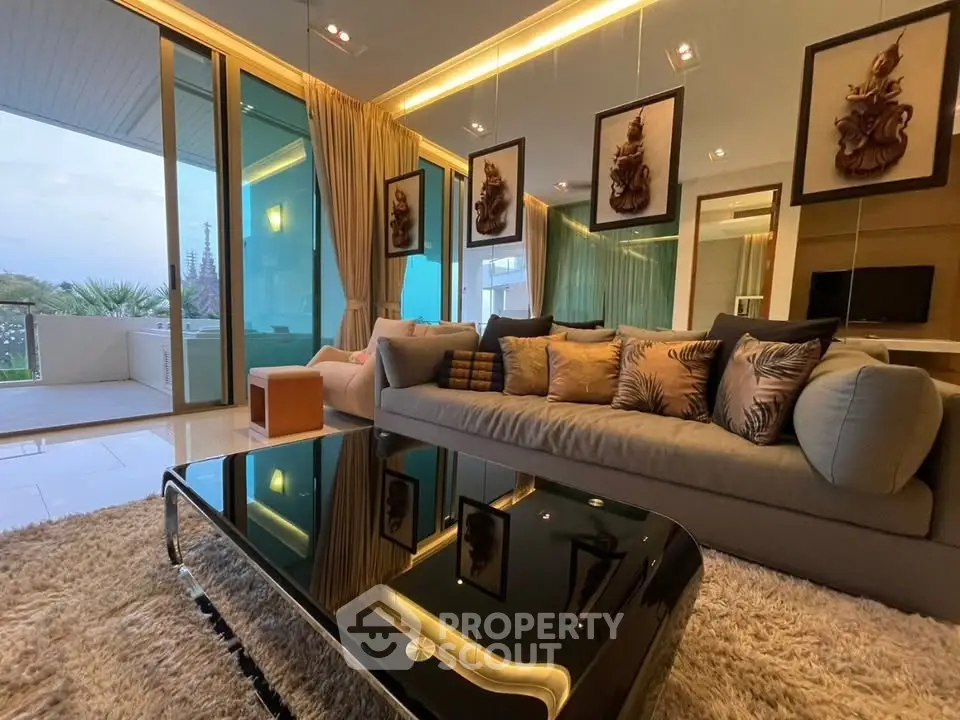 Luxurious living room with modern decor and large glass doors opening to a spacious balcony with a view.