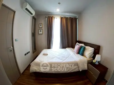 Cozy bedroom with modern decor and natural light, featuring a comfortable bed and stylish accents.