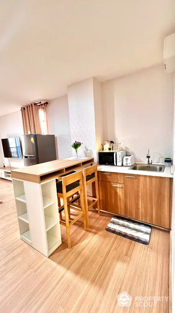 Modern kitchen with wooden cabinets and breakfast bar in open layout apartment