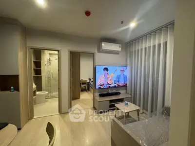 Modern living room with TV, air conditioning, and open view to bathroom and bedroom.
