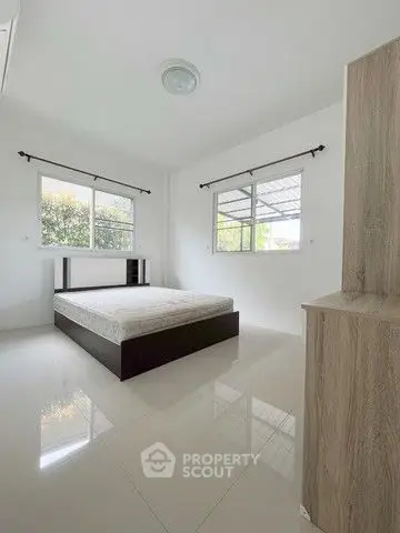 Spacious minimalist bedroom with large windows and modern design.