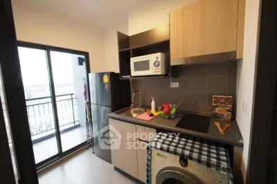 Modern kitchen with balcony access, featuring sleek appliances and stylish cabinetry.