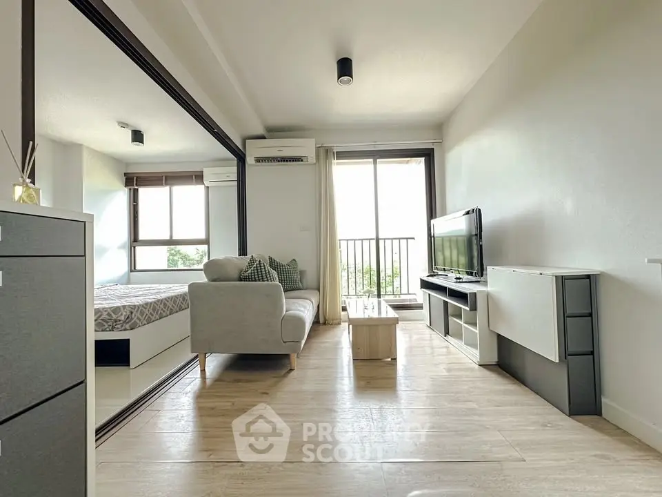Modern living room with balcony and sleek furniture, bright and airy space.
