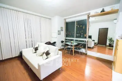 Modern living room with wooden flooring and city view window.