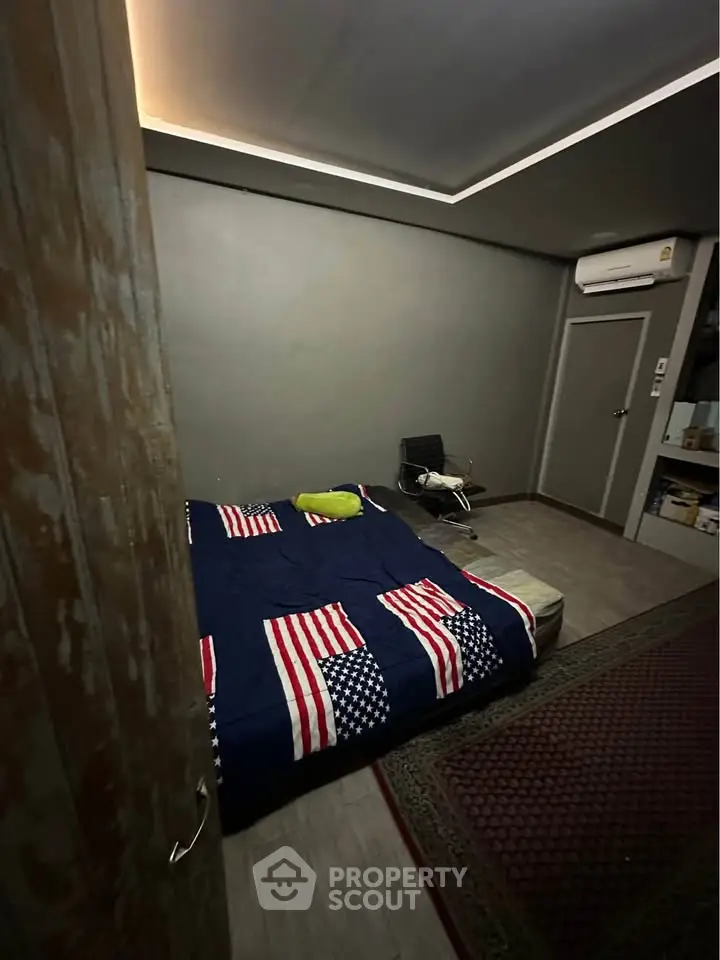 Cozy bedroom with American flag bedding and modern air conditioning unit.