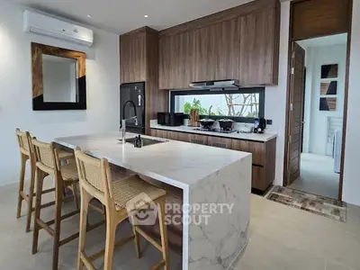 Modern kitchen with marble island and wooden cabinetry, featuring open layout and stylish bar stools.