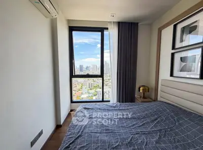Modern bedroom with city view, featuring stylish decor and large window for natural light.