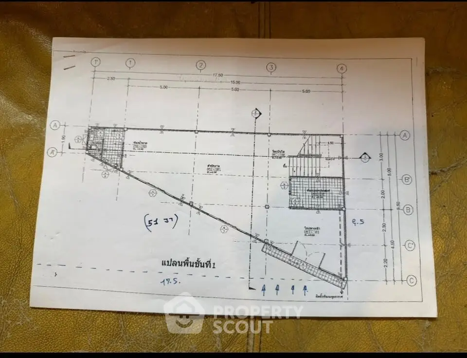 Architectural floor plan on a table showcasing unique layout and dimensions.