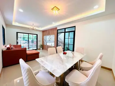 Luxurious open-plan living and dining area with elegant marble table and plush seating, perfect for entertaining.