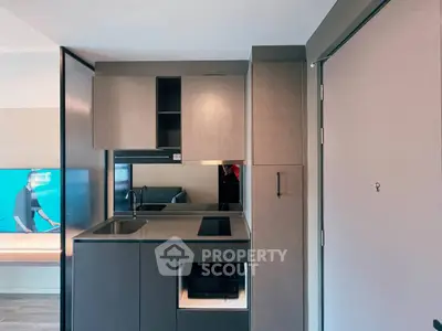 Modern compact kitchen with sleek cabinetry and built-in appliances in a stylish apartment.