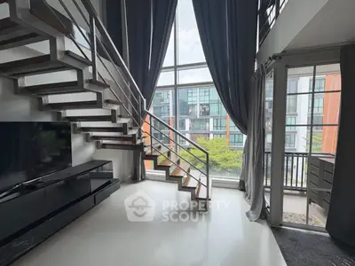 Modern loft with stylish staircase and large windows offering city views