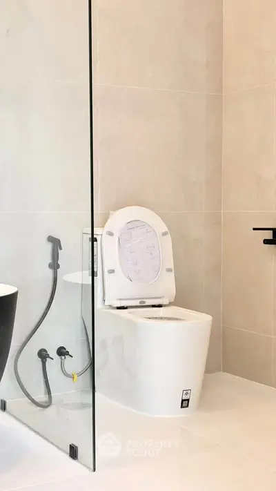 Modern bathroom with sleek toilet and glass shower partition