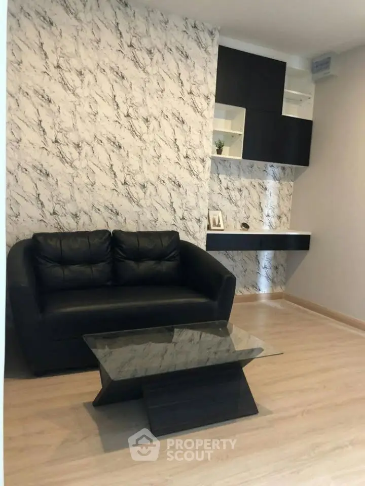 Modern living room with stylish black sofa and marble accent wall