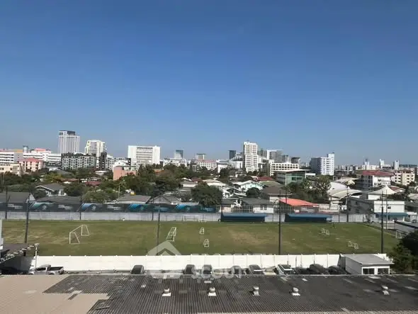 Stunning cityscape view from a high vantage point overlooking a soccer field and urban skyline.