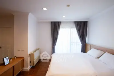 Spacious bedroom with elegant decor and natural light in modern apartment