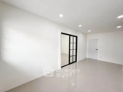 Spacious modern room with sleek tile flooring and glass sliding doors