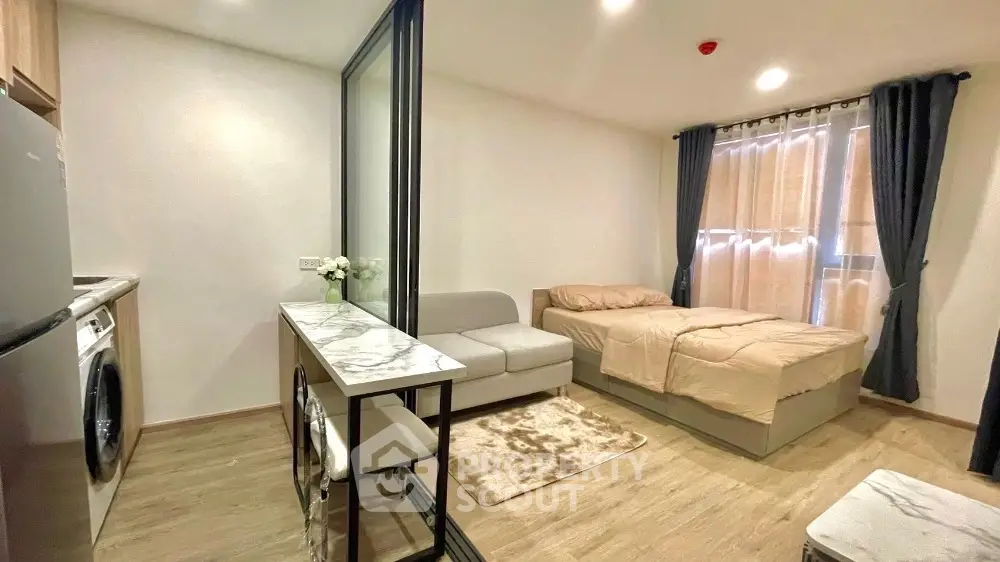 Modern studio apartment with cozy bed, compact kitchen, and stylish decor