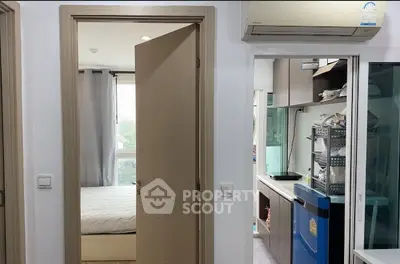 Modern apartment interior with bedroom and kitchen view, featuring sleek design and natural light.