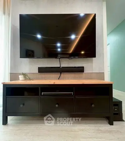 Modern living room with sleek TV setup and stylish wooden console.