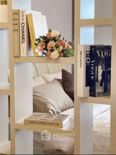 Stylish bedroom with decorative bookshelf and elegant bedding