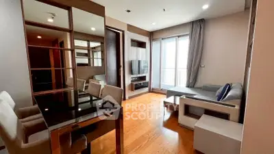 Modern living room with wooden flooring and stylish furniture, featuring a large window for natural light.