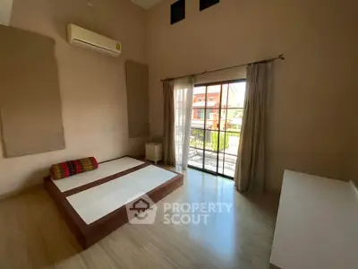 Spacious bedroom with large window and minimalist decor