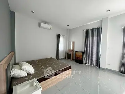 Spacious modern bedroom with sleek design and ample natural light.
