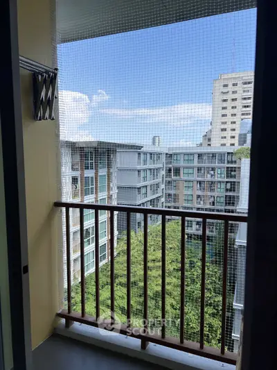 High-rise apartment balcony with city view and safety netting, perfect for urban living.