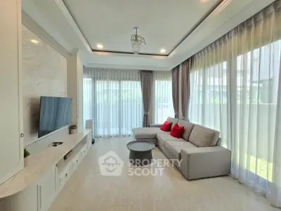 Elegant living room with modern decor, large windows, and cozy seating area.